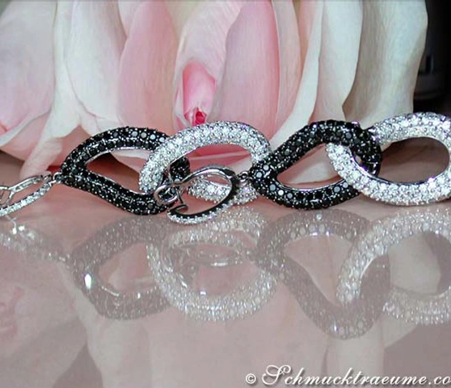 Schwarz-weißes Diamant-Ohrgehänge mit Ringform, vor Rosenblüte. Schwarz-weißes Diamant-Ohrgehänge mit Ringform, vor Rosenblüte.