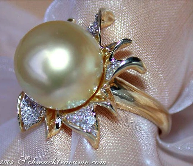 Blütenformiger Goldring mit Perle und Diamanten, Detailaufnahme auf Satin. Blütenformiger Goldring mit Perle und Diamanten, Detailaufnahme auf Satin.