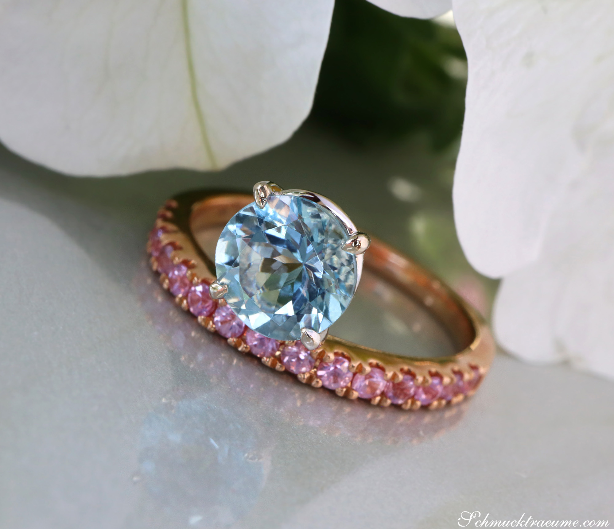 Raffinierter Aquamarin-Ring mit rosa Saphiren, Detailaufnahme auf grauem Untergrund