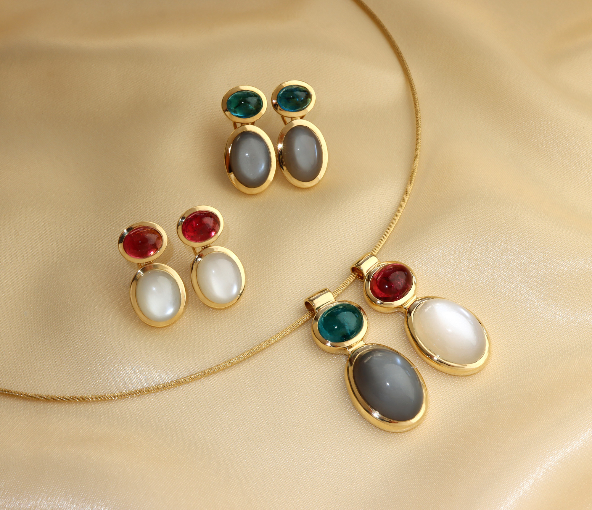 Goldene Ohrringe mit Rubellit und Mondsteinen in verschiedenen Farben