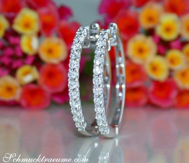 Klassische Creolen aus Weißgold 750 mit glänzenden Diamanten, floraler Hintergrund Klassische Creolen aus Weißgold 750 mit glänzenden Diamanten, floraler Hintergrund