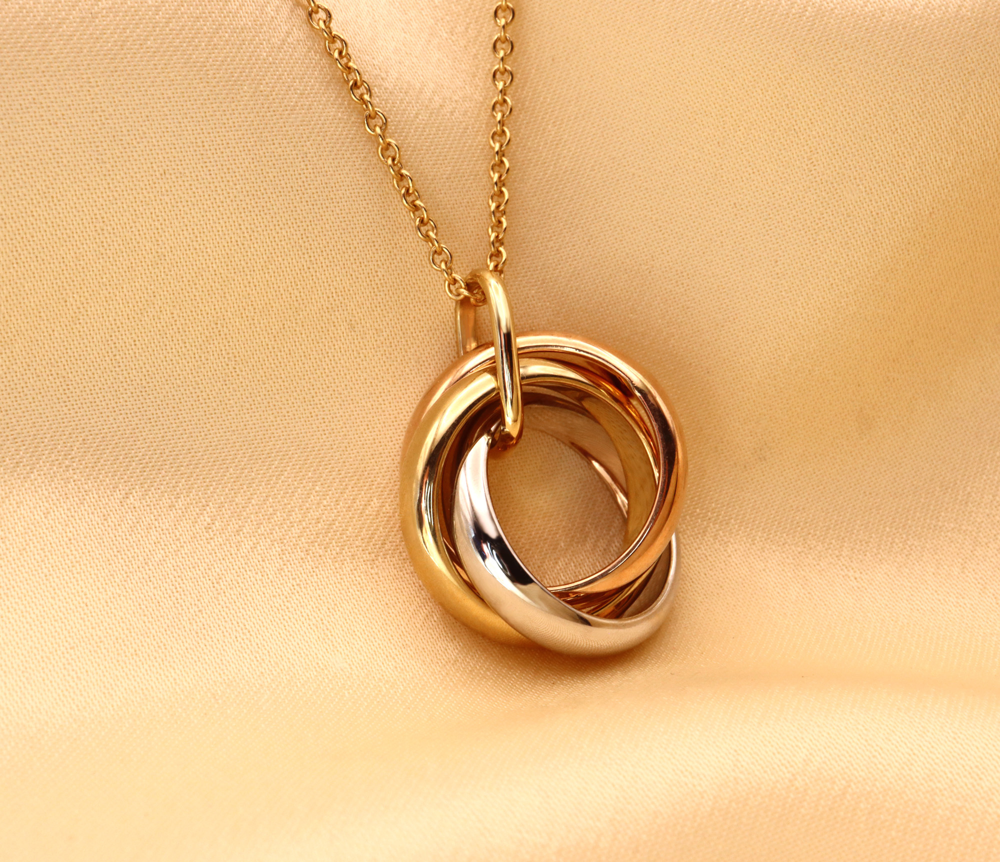 Gold Anhänger "Tricolor" mit verschränkten Ringen auf Kette, Detailaufnahme