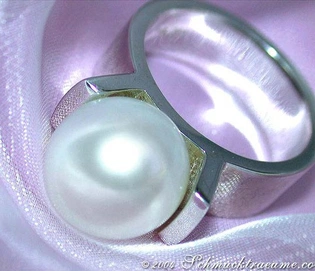 Weißgold 585 Ring mit großen Südseeperle, Detailaufnahme auf lila Stoff.