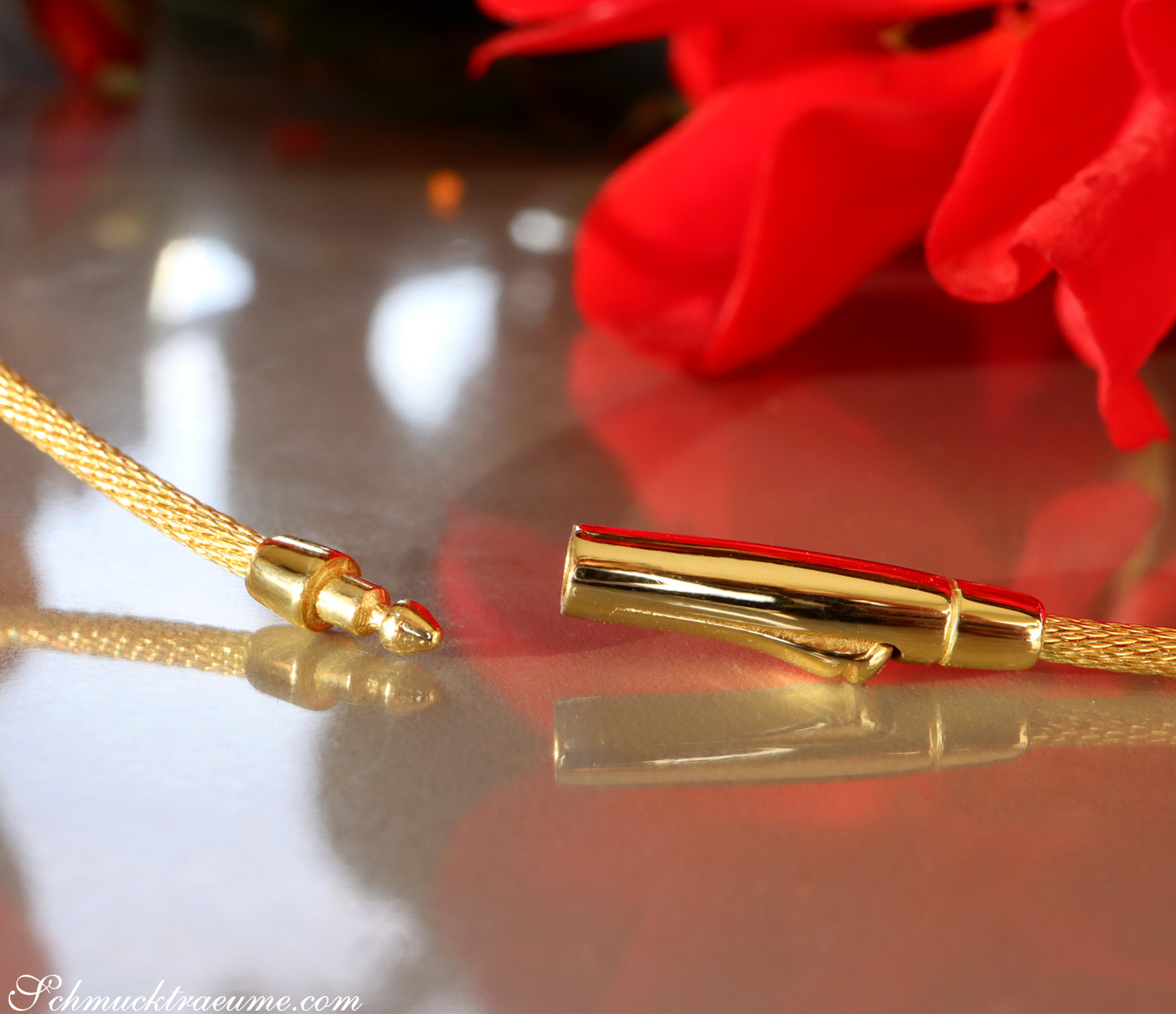 Detailaufnahme des goldenen Karabinerverschlusses eines Colliers mit funkelnden Brillanten.