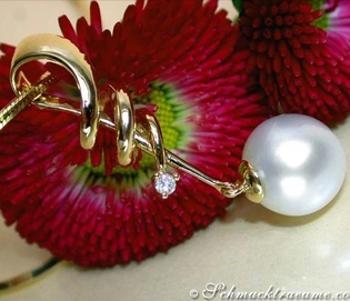 Goldener Anhänger mit Perle und Diamant, detailreich, elegant, auf Blume präsentiert.