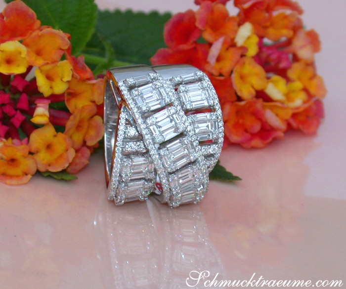 Diamantring mit Baguette-Steinen, überkreuzte Struktur, weißgold, 2.370 Karat, Blumen im Hintergrund.
