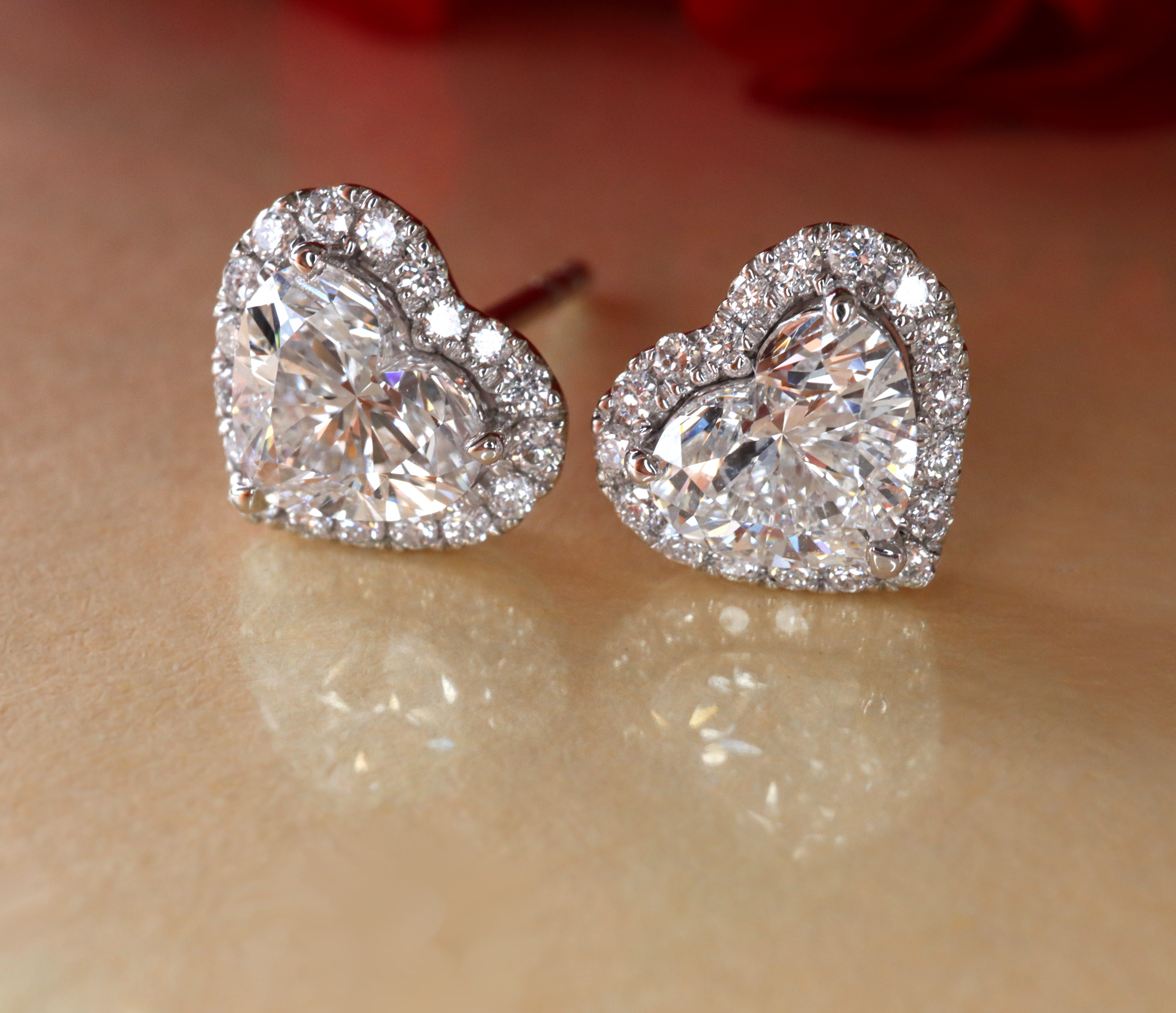 Herzformige Diamant-Ohrstecker in Weißgold, funkelndes Herz mit Diamantenrand.