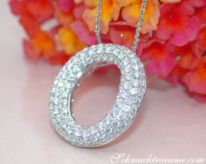 Kreisförmiger Brillantenpavé-Anhänger in Weißgold, detailreich, vor Blütenhintergrund