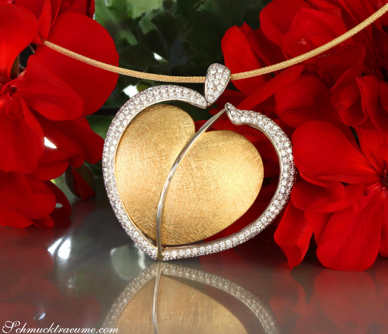 Herz-Anhänger aus Gelbgold mit Brillanten, detailreiches Herzmotiv, rote Blumen im Hintergrund