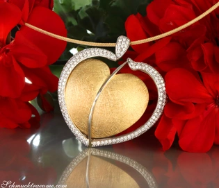 Herz-Anhänger aus Gelbgold mit Brillanten, detailreiches Herzmotiv, rote Blumen im Hintergrund