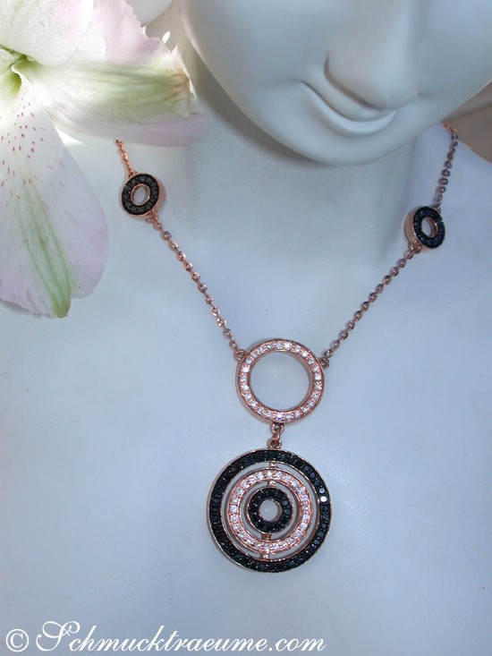 Ungewöhnliche Halskette mit schwarzen und weißen Diamanten in Roségold, getragen am Hals eines Puppenkopfes, zarte Blume im