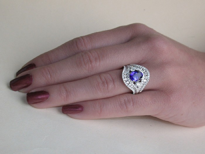 Weißgoldring mit AAA-Tansanit und Brillanten, Detailaufnahme auf Hand, sanfte Formen