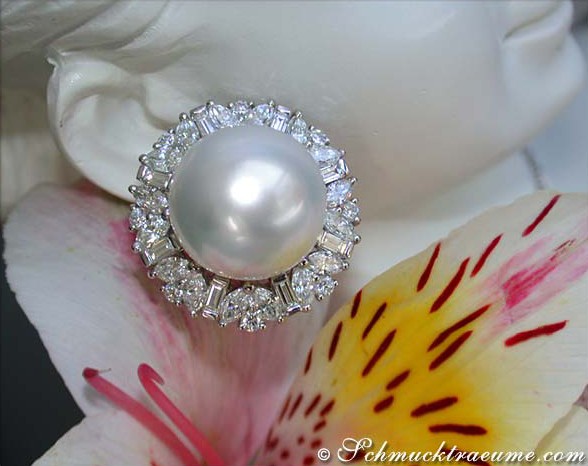 Südseeperlen-Ohrstecker mit Diamanten, Detailaufnahme, Blume im Hintergrund