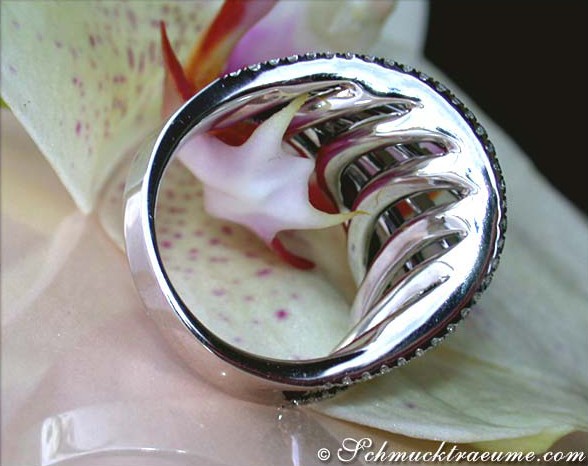 Schwarzer Diamant-Ring mit weißem Gold, Detailaufnahme, auf Blume getragen