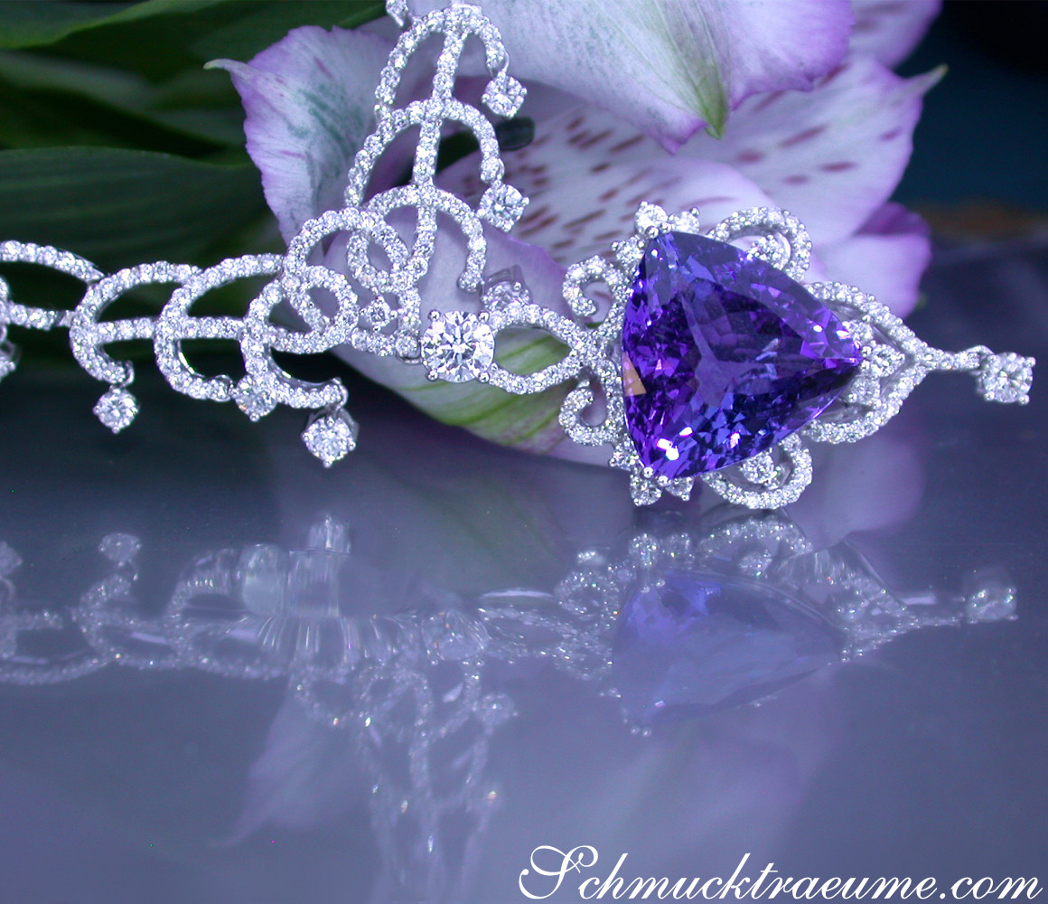 Detailliertes Collier mit Tansanit und Brillanten, luxuriöses Design, blühende Blume im Hintergrund.