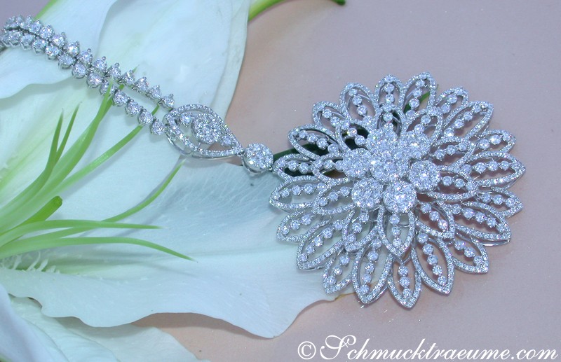 Detaillierter Brillantenanhänger mit blütenförmigem Design auf Blüte liegend