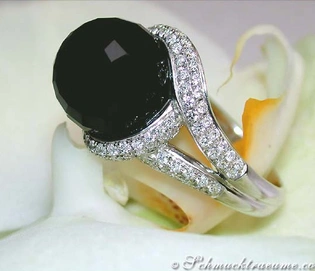 Onyx-Ring mit Brillanten auf weißem Blütenhintergrund