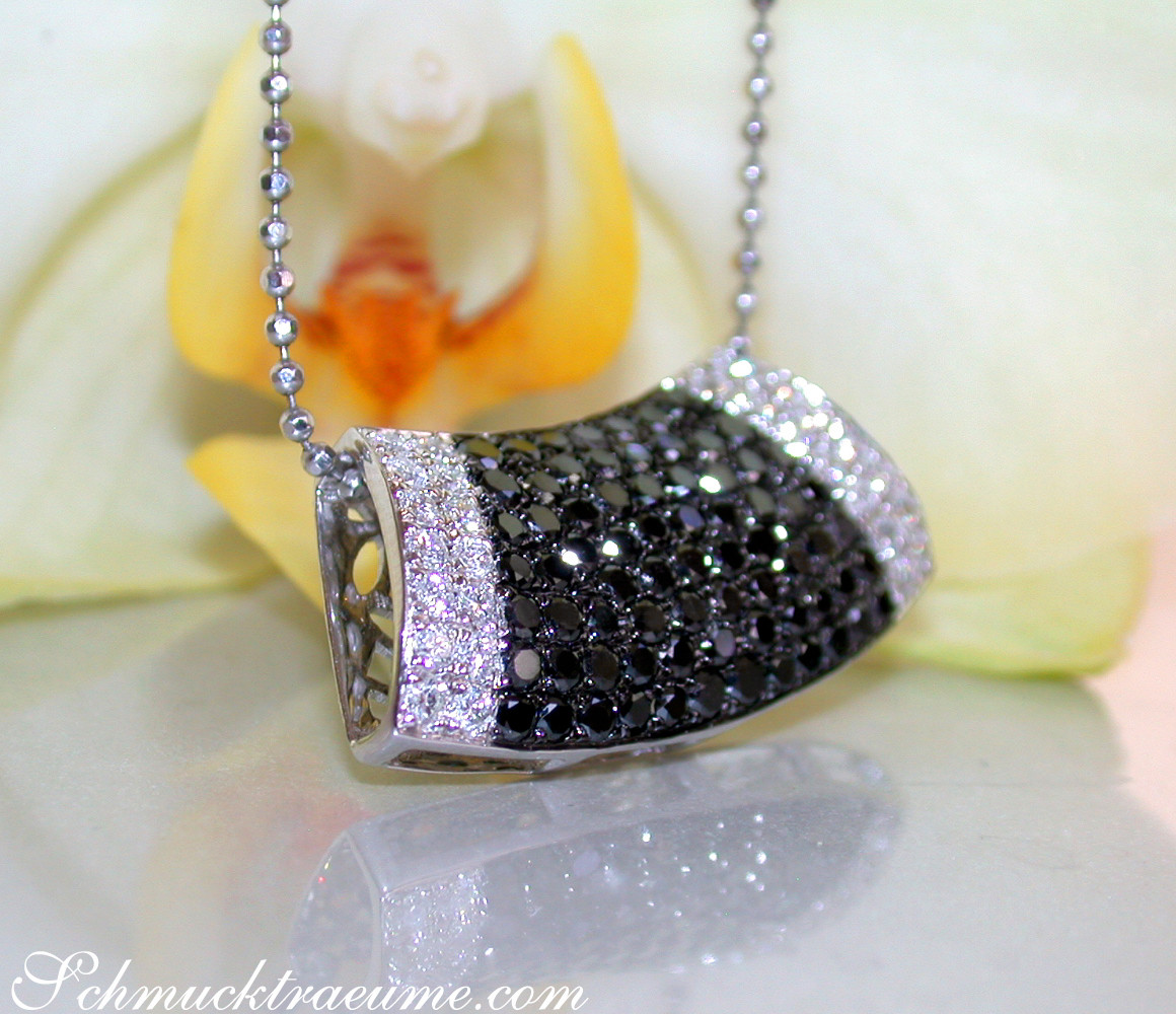 Schwarz-weiß-Diamantanhänger mit Kettenhaken, detailreich, auf Blüte liegend.