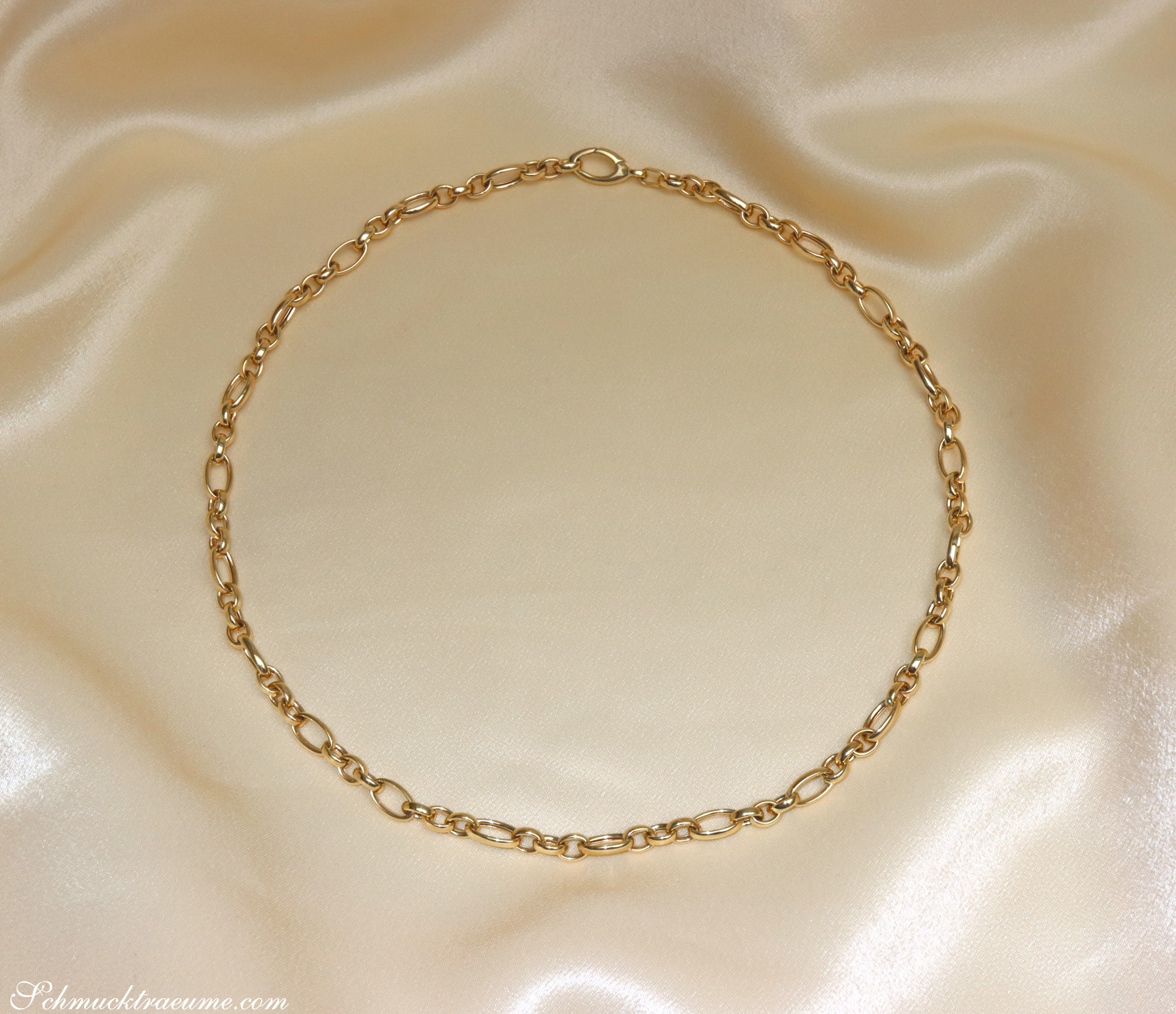 Gelbgold 585 Glieder Collier auf cremefarbenem Stoff, elegant und chic.