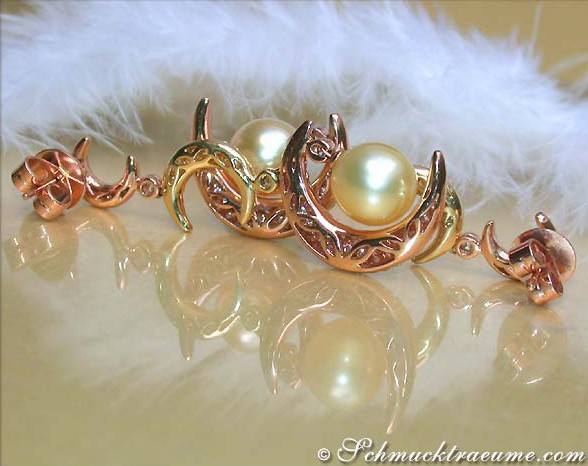 Goldene Perlenohrringe mit Brillanten auf flauschigem Hintergrund