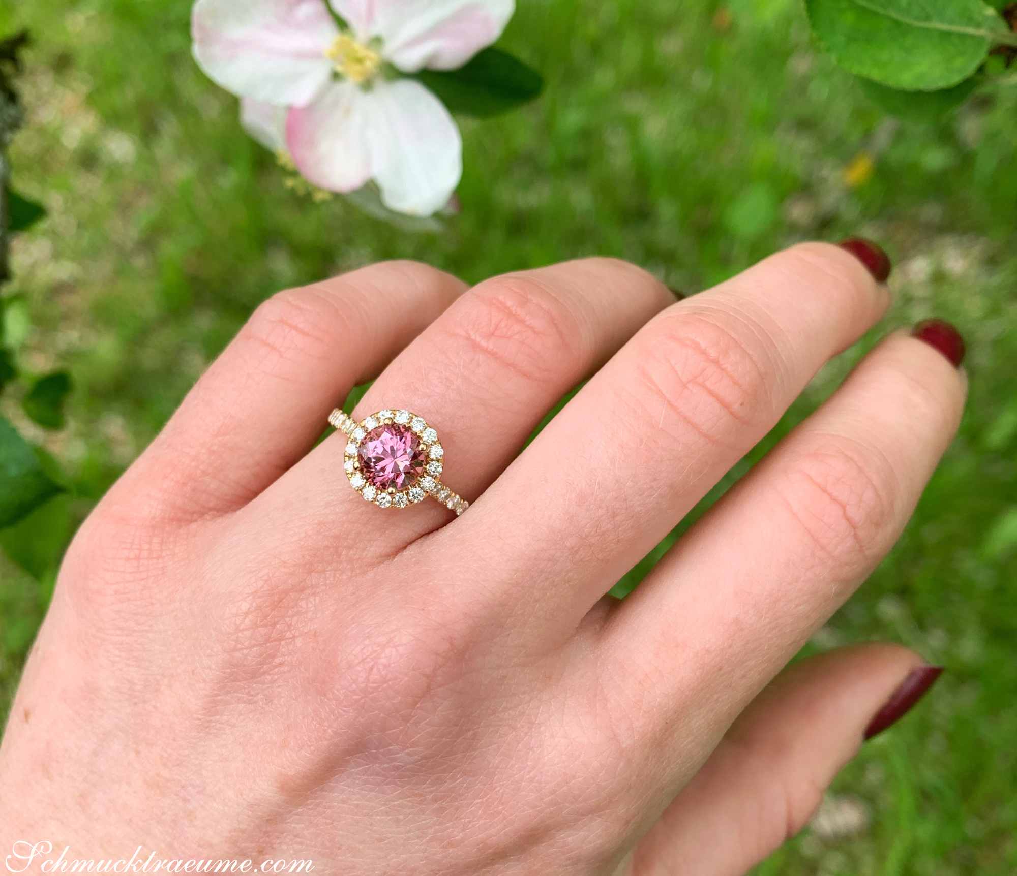 Rosa Granat-Ring mit Brillanten auf grünem Hintergrund