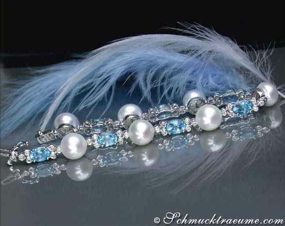 Schönes Süßwasserperlen-Armband mit Blautopasen und Brillanten, Feder im Hintergrund