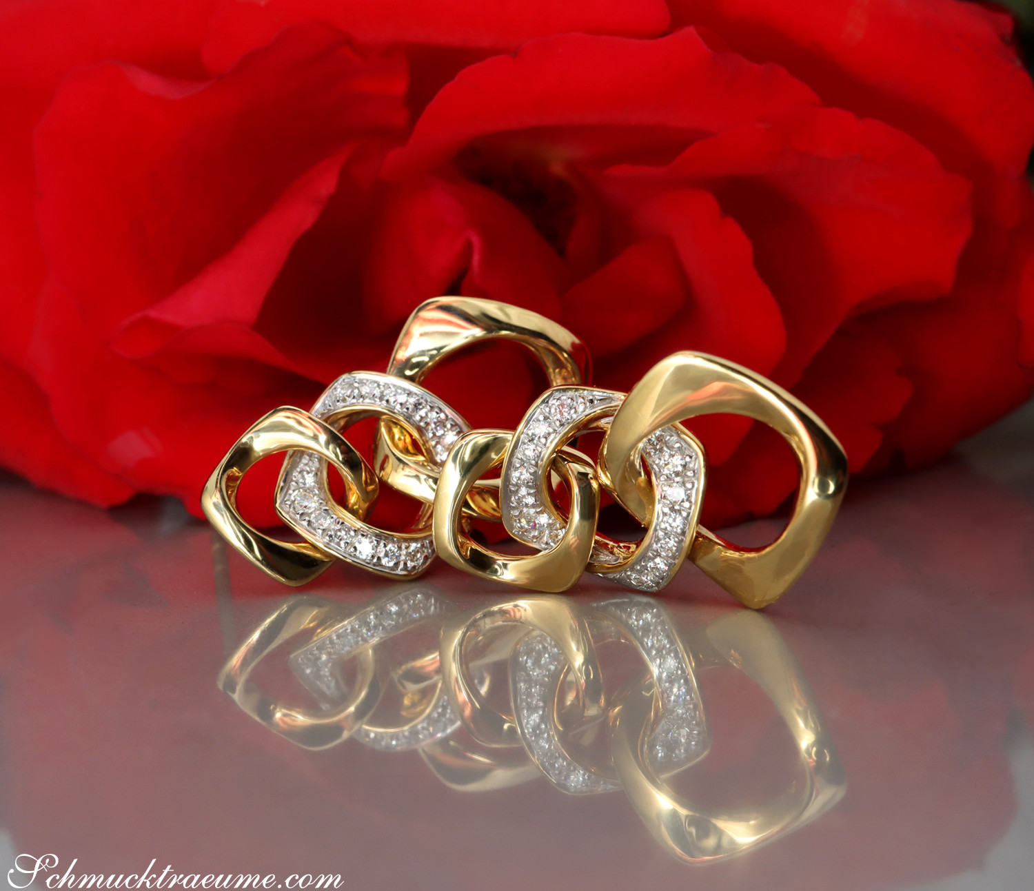Gelbgold-Brillanten-Ohrringe im Glieder-Design vor roter Rose, glänzende Haptik, detailreich.
