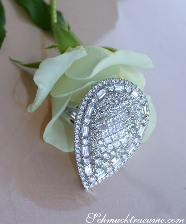 Weißgold 750 Tropfenring mit Diamanten, Detailaufnahme, Rosenblüte im Hintergrund