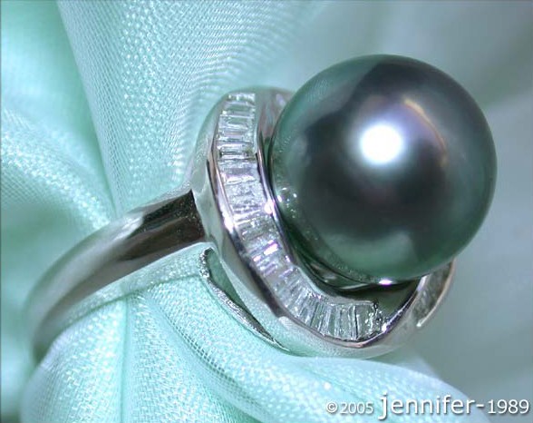 Tahitiperlenring mit Trapez-Diamanten auf Silbergrund, detailreich auf Satin.