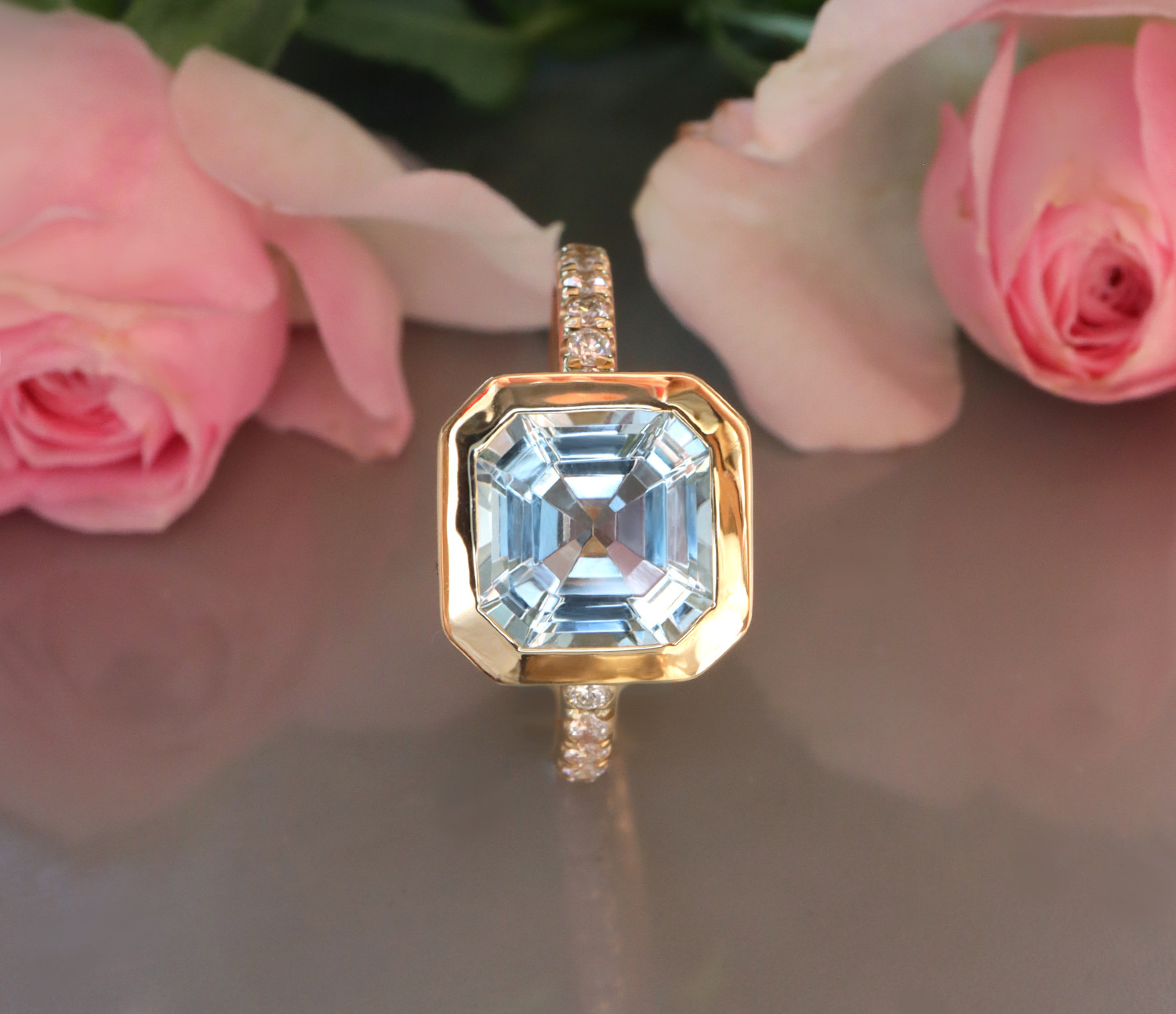 Aquamarin-Ring mit Brillanten in Gelbgold, Detailaufnahme, Rosen im Hintergrund