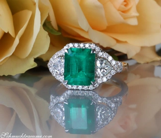 Klassischer Smaragd-Ring mit Diamant-Herzen, detailreich, auf Rosenblüte gestellt