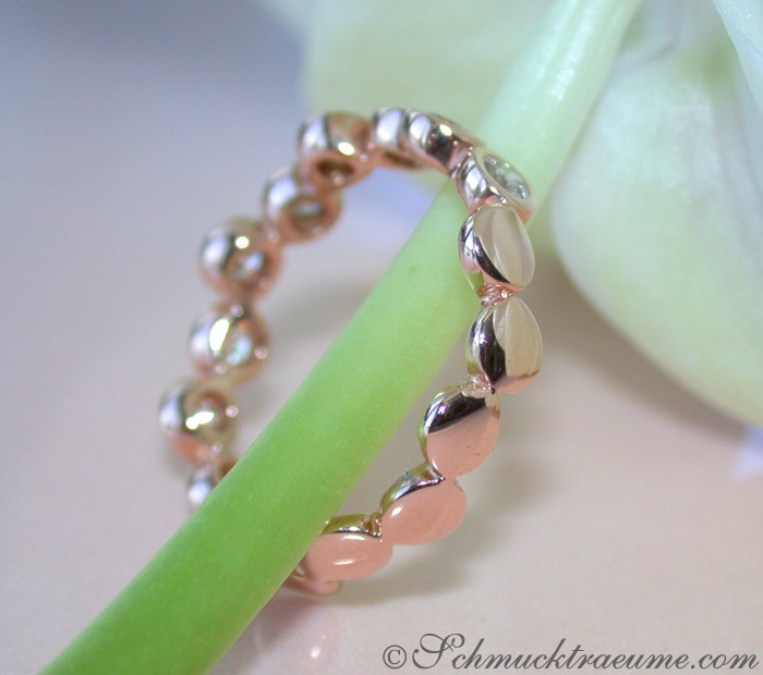 Edler Diamanten Memory Ring in Roségold: Detailaufnahme mit Perlenbesatz auf grünem Hintergrund