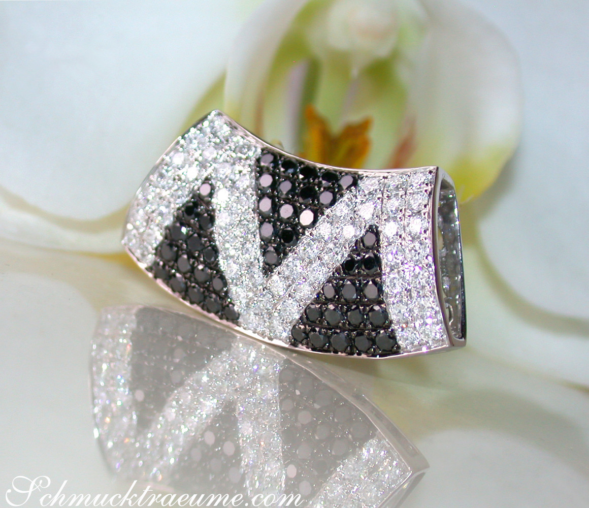 Weißgold-Zick-Zack-Anhänger mit schwarzen & weißen Diamanten, Blume im Hintergrund