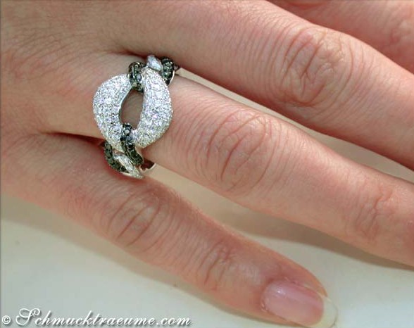 Diamantring mit schwarz-weißen Diamanten in Gliederform auf Handfinger.