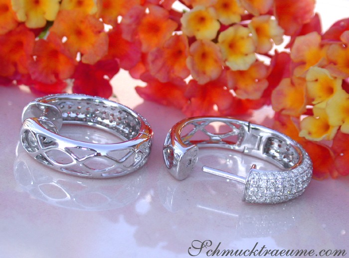 Klassische Creolen aus Weißgold mit Brillanten, blühende Blumen im Hintergrund