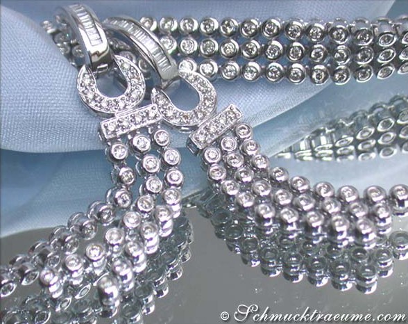 Weißgold-Ohrgehänge mit Brillanten, detailreich, auf blauem Stoff liegend.