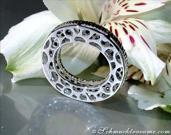 Schwarzer Diamanten-Kreis-Anhänger mit feinen Details, getragen auf Blütenblättern.