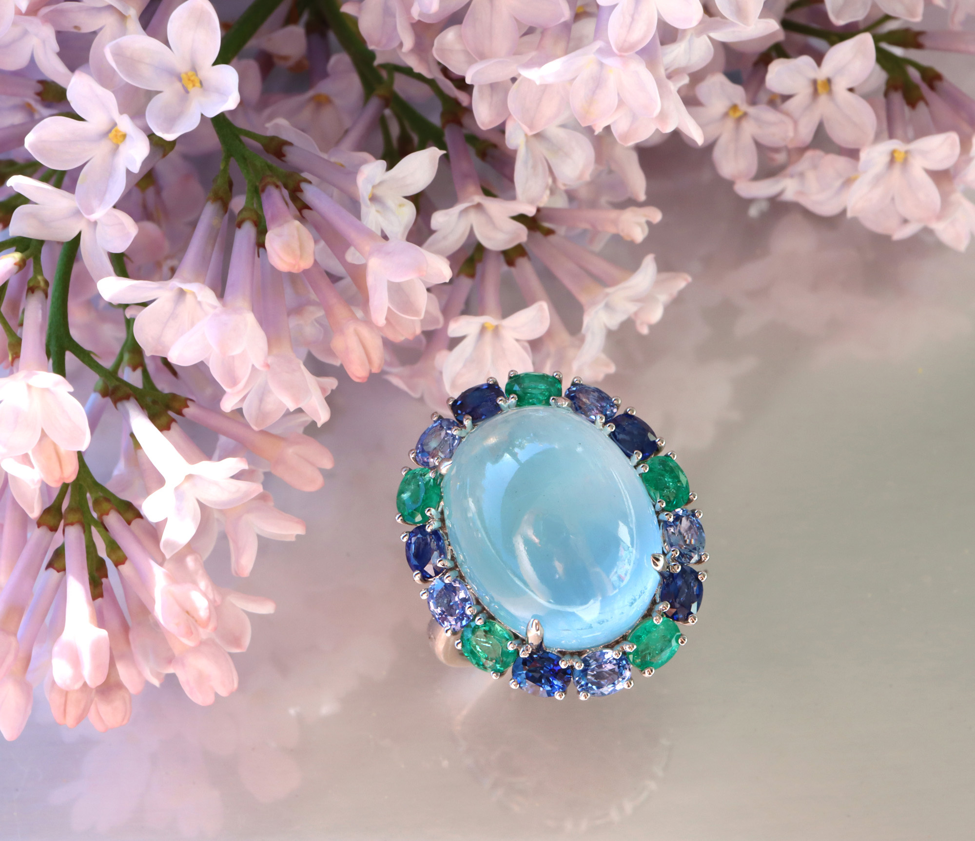 Milky Aquamarin-Ring mit Saphiren und Smaragden, Detailansicht auf Lilienblüten.