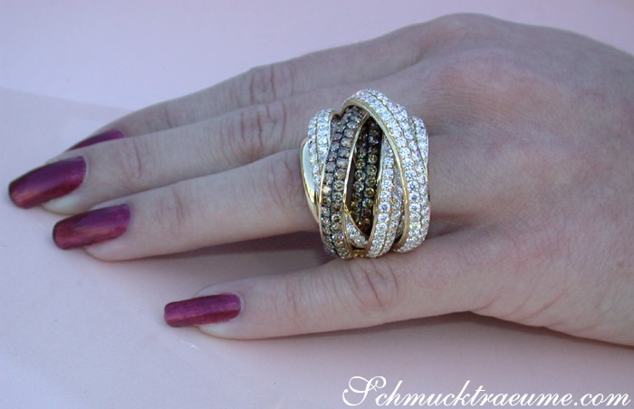 Goldener Mehrreihiger Brillantenring mit naturbraunen Steinen, elegant getragen.