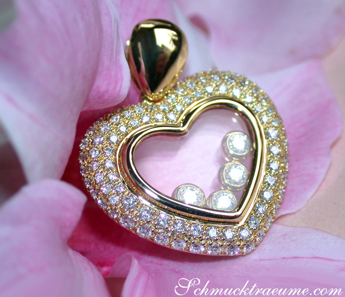 Goldener Herzanhänger mit Diamanten auf Blütenblatthintergrund