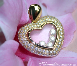 Goldener Herzanhänger mit Diamanten auf Blütenblatthintergrund