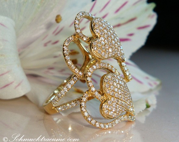 Goldener Diamant Herz-Ring mit feinen Brillanten, Detailaufnahme von oben, auf Blütenblatt liegend.