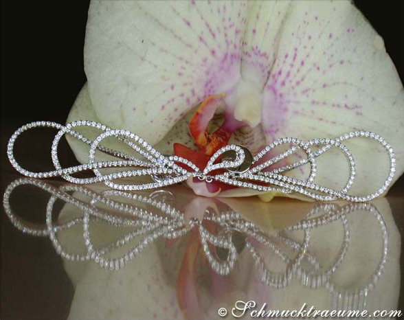 Extra lange Brillant-Tropfen-Ohrhänger in Weißgold, detailreich verziert, vor Orchidee abgebildet