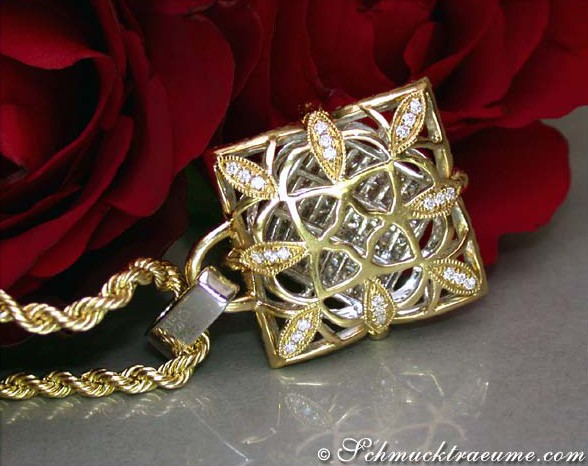 Goldener Anhänger mit Diamanten, Detailaufnahme, rote Rosen im Hintergrund