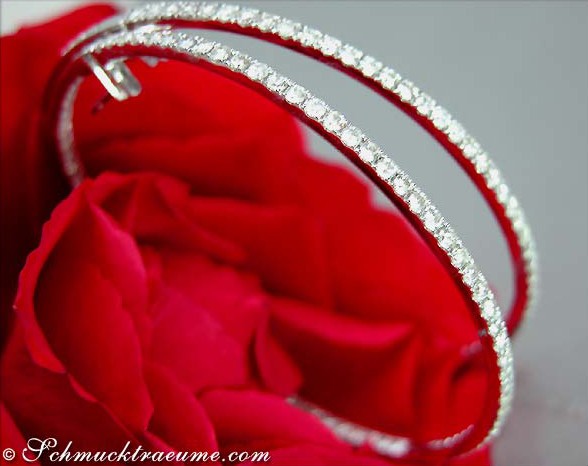 Detailansicht von Weißgoldcreolen mit 3.290 Karat Brillanten auf rotem Stoff