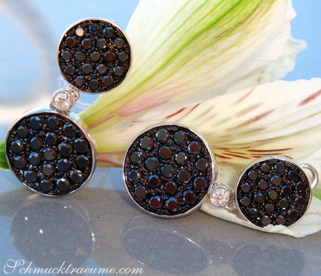 Schwarze Diamanten Ohrgehänge in Weißgold, detailreich mit Brillanten, auf Blüte präsentiert Schwarze Diamanten Ohrgehänge in Weißgold, detailreich mit Brillanten, auf Blüte präsentiert