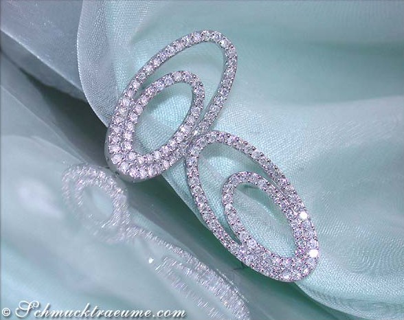 Detail der brillanten Ellipsen Ohrstecker auf türkisfarbenem Stoff