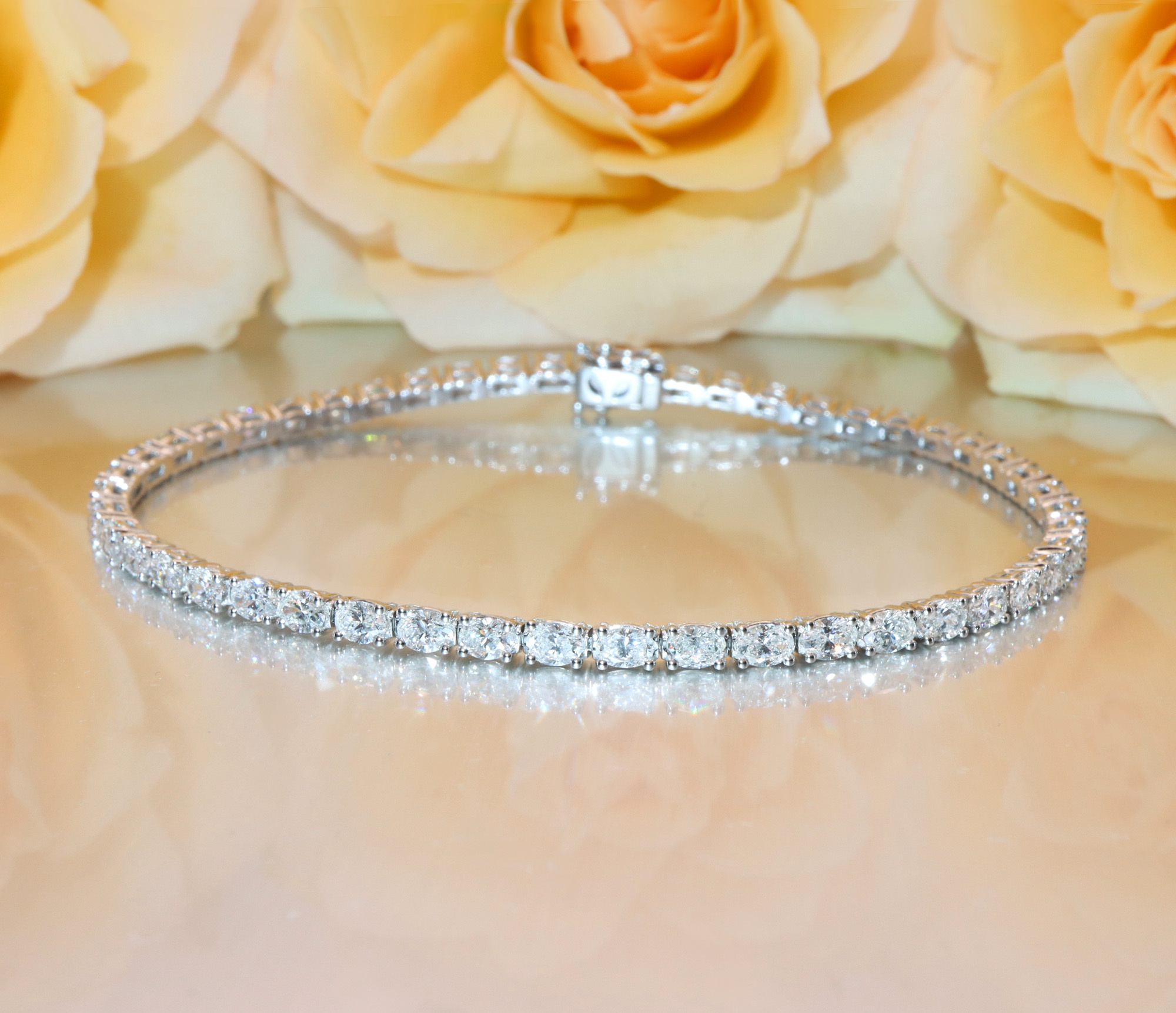 Diamant-Tennisarmband im Ovalschliff auf Rosenhintergrund, Detailaufnahme