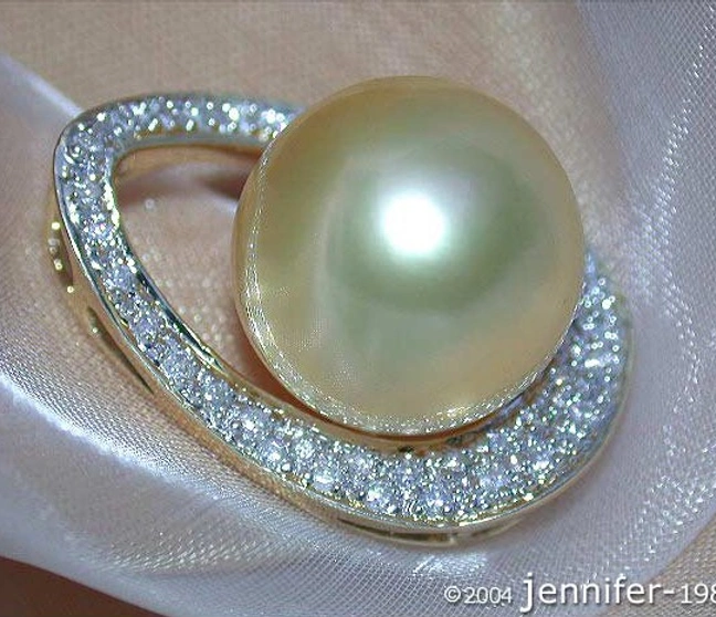 Gelbgold-Anhänger mit großen Südseeperle und Brillanten, elegant auf weißem Tuch. Gelbgold-Anhänger mit großen Südseeperle und Brillanten, elegant auf weißem Tuch.