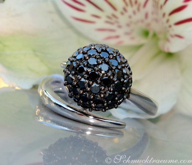 Schwarzdiamant-Kugelring in Weißgold 585, detailreich, elegant, auf Blüte präsentiert. Schwarzdiamant-Kugelring in Weißgold 585, detailreich, elegant, auf Blüte präsentiert.